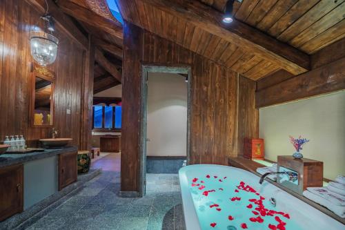 a bathroom with a bath tub and wooden walls at Arro Khampa By Zinc Journey Shangri-la in Shangri-La
