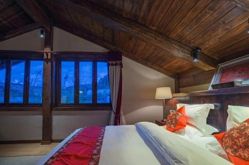 a bedroom with a bed in a room with windows at Arro Khampa By Zinc Journey Shangri-la in Shangri-La