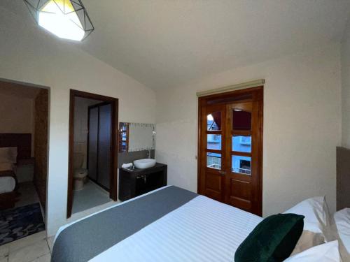 una camera con letto e un bagno con lavandino di Hotel Orquídea a Zacatlán