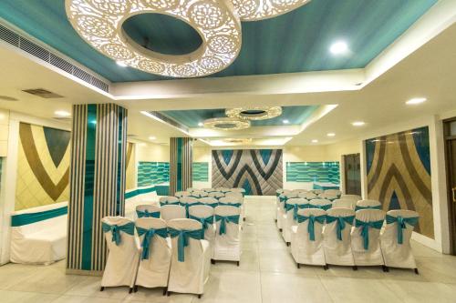 a room with rows of chairs and a chandelier at Hotel Annapoorna Residency in Hyderabad