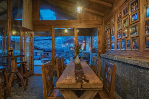a dining room with a wooden table and chairs at Arro Khampa By Zinc Journey Shangri-la in Shangri-La