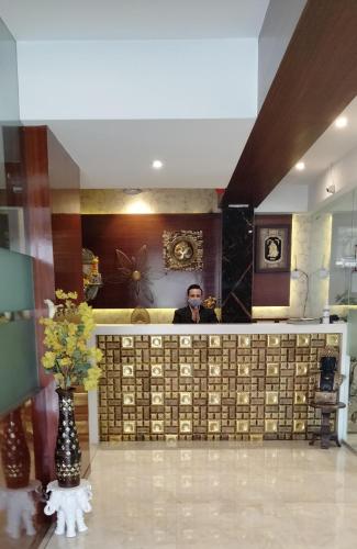 a man is standing behind a counter in a room at Shikin Hotels (Close to Palm Beach Road) in Navi Mumbai
