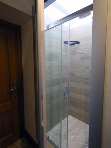 a glass shower in a room with a door at Piccolo di Piazza di Spagna Suites in Rome