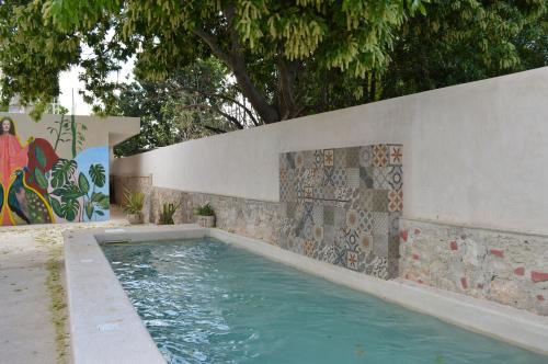 a swimming pool with a stone wall and a tile wall at CASA LÁZARO- Hermosa casa familiar in Mérida