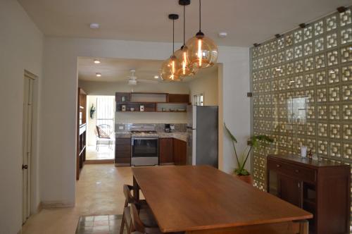 a kitchen with a wooden table and a dining room at CASA LÁZARO- Hermosa casa familiar in Mérida