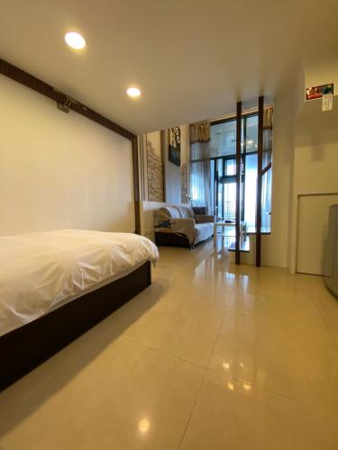 a bedroom with a bed and a living room at 山玥溫泉 in Jiaoxi