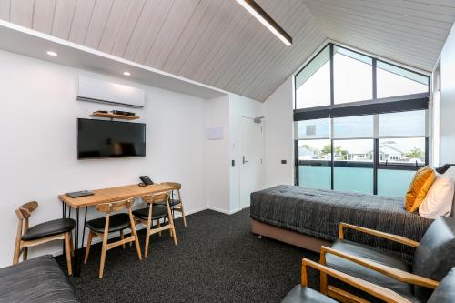 a bedroom with a bed and a desk in a room at The Strand in New Plymouth