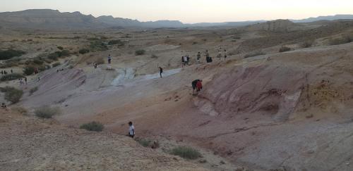 a group of people walking on a hill in the desert at עדן במדבר - eden in desert in Yeroẖam