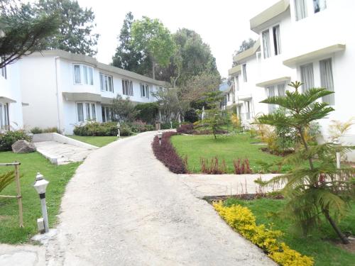 a dirt road in front of white houses at Sterling Kodai Lake in Kodaikānāl