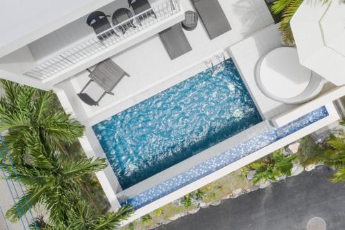an overhead view of a swimming pool in a house with palm trees at KEN KEN VILLA YUUMODORO in Motobu
