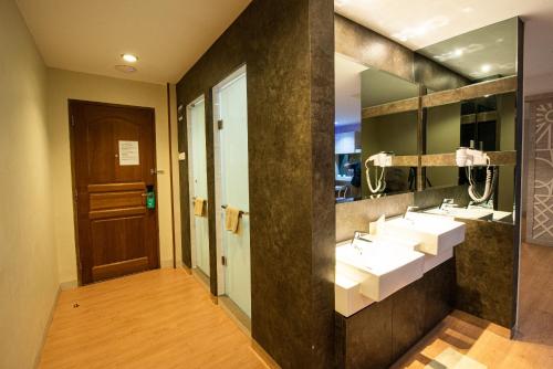 a bathroom with two sinks and two mirrors at Lovina Inn Penuin in Nagoya