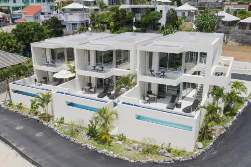 an aerial view of a white house with a swimming pool at KEN KEN VILLA YUUMODORO in Motobu