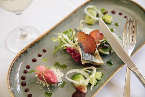 a plate of food on a table with a fork and knife at The Falcon Hotel in Uppingham