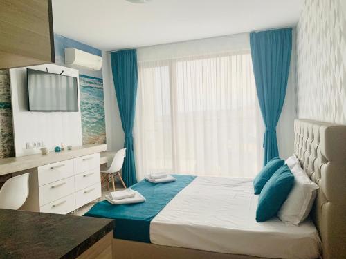a bedroom with a bed and a desk and a window at Studio in Diamond Beach in Burgas