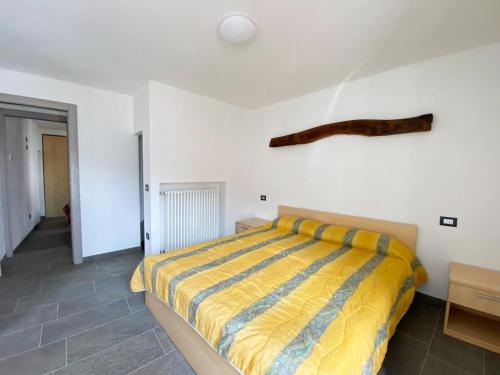 a bedroom with a bed with a yellow and blue blanket at Independent Stone House with Lake View in Musso