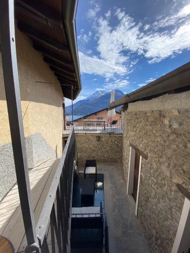 a balcony with tables and chairs on a building at Independent Stone House with Lake View in Musso