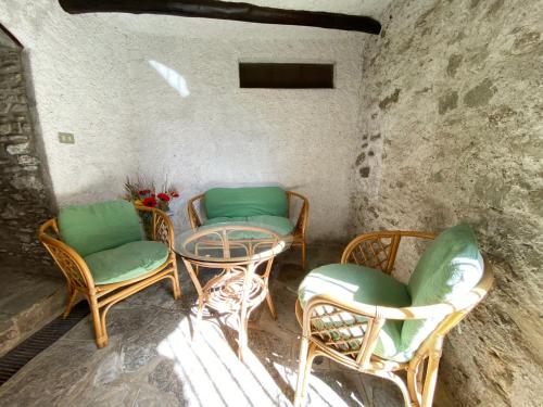a patio with chairs and a table and a table at Independent Stone House with Lake View in Musso