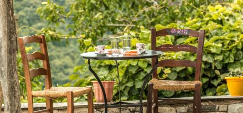 a table with two chairs and a table with drinks on it at Archontiko Filippidi in Miléai