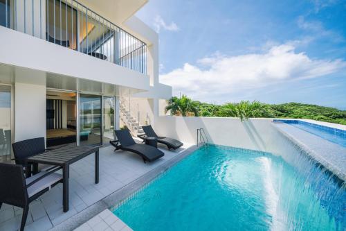a house with a swimming pool next to a building at KEN KEN VILLA YUUMODORO in Motobu