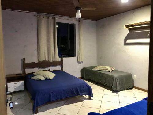 a bedroom with two beds and a window at Regi House Hostel in Vitória