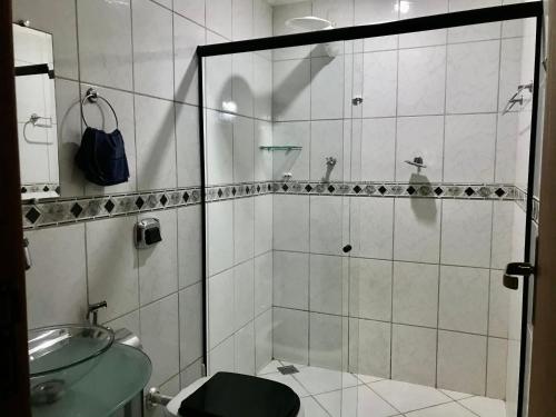a bathroom with a shower with a toilet and a sink at Regi House Hostel in Vitória