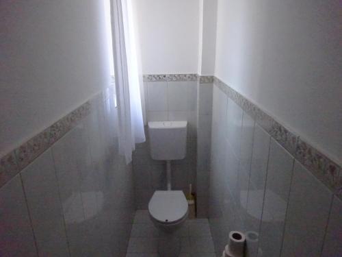 a small bathroom with a toilet and a window at Deluxe szoba in Eger