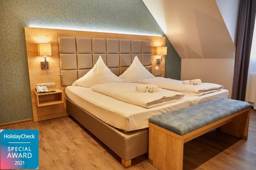 a bedroom with a large bed with a headboard at Bernstein Acamed Resort in Nienburg