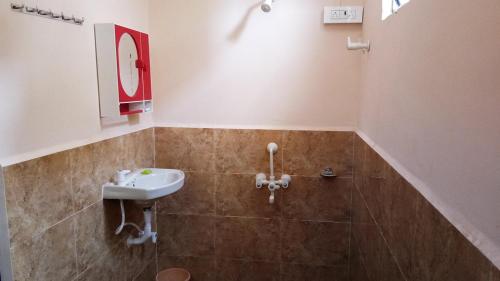 y baño con lavabo y ducha. en Kamat Cottages en Dāhānu