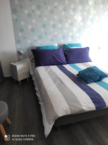 a bedroom with a bed with blue and purple pillows at Mas de Grezes in Gaillac