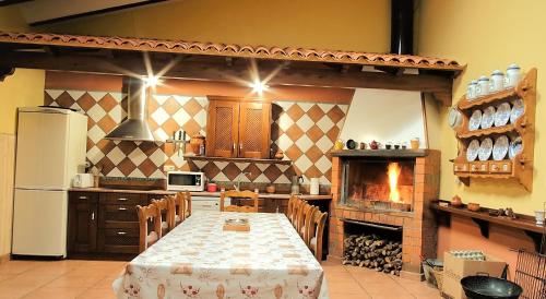 a large kitchen with a table and a fireplace at Casa Rural Don Alonso in Villalgordo del Jucar