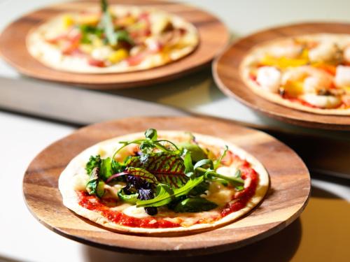 a pizza on a wooden plate on a table at Lake Shikotsu Tsuruga Resort Spa Mizu no Uta in Chitose