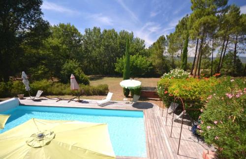 een zwembad met stoelen en parasols in een tuin bij Les flamants roses in Roussillon