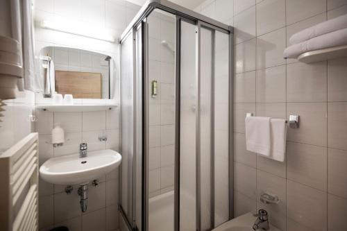 a bathroom with a shower and a sink and a toilet at Hotel Plan Murin in La Valle