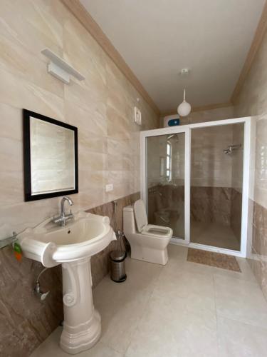 uma casa de banho com um lavatório e um WC em Windermere Inn em Shillong