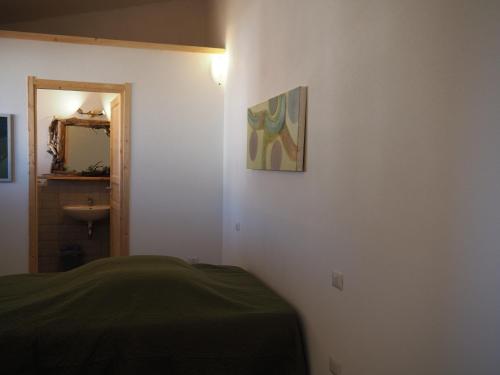 a room with a bed and a painting on the wall at Stazzu Giasti Agriturismo in Aglientu