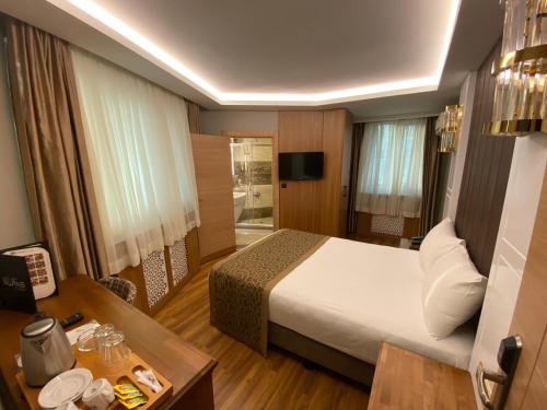 a hotel room with a bed and a desk at Gumus Palace Gungoren in Istanbul