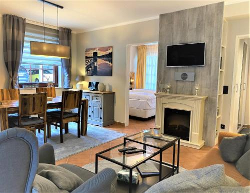 een woonkamer met een bank en een open haard bij Luxus Ferienwohnung Ausspann in Hahnenklee-Bockswiese