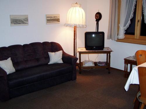 a living room with a couch and a tv at Ferienwohnungen Ingrid Schillmeier in Schönau am Königssee