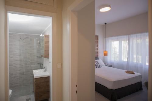 a bedroom with a bed and a bathroom with a shower at Anemelia Luxury Apartments in Argostoli