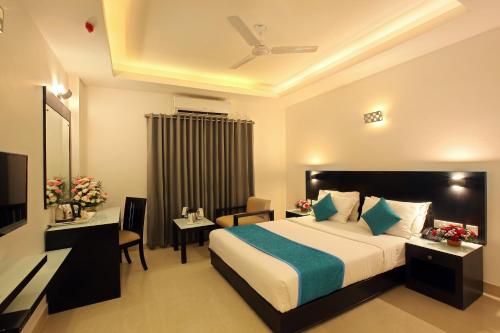 een hotelkamer met een bed en een bureau bij Park Residency in Kozhikode