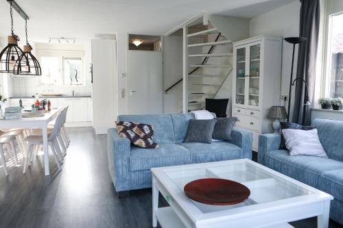 a living room with a blue couch and a table at Vakantiewoning 114 in villapark de oesterbaai in Wemeldinge