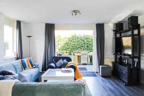 a living room with a couch and a table at Vakantiewoning 114 in villapark de oesterbaai in Wemeldinge