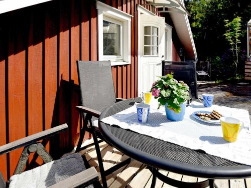 une table et des chaises sur une terrasse avec une table et des fleurs dans l'établissement 4 person holiday home in UDDEVALLA, à Mosshed