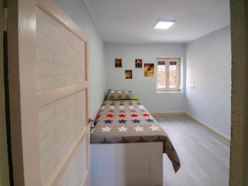 Habitación con cama en la esquina de una habitación en La Casita de la Neka, en Villarcayo