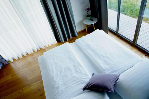 Sofá blanco con almohada en una habitación con ventana en Walters Weinquartier, en Eisenberg an der Pinka