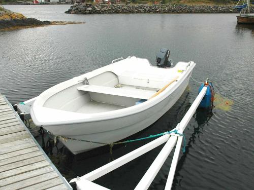a white boat tied to a dock in the water at 6 person holiday home in Farstad-By Traum in Farstad