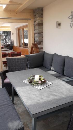 a living room with a gray couch and a table with a candle at Haus Binder in Ried im Zillertal