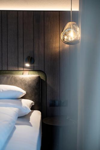 a bedroom with a bed with two pillows and a lamp at Hotel Plan Murin in La Valle