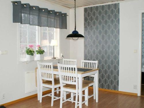Håcksvik的住宿－Two-Bedroom Holiday home in Håcksvik 2，一间配备有白色桌椅的用餐室