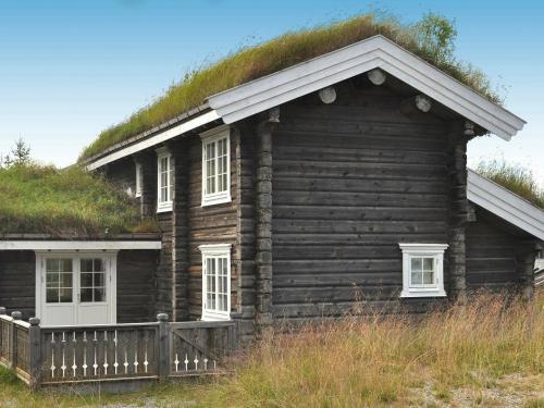 una vecchia casa di tronchi con tetto in erba di 8 person holiday home in F vang a Tromsnes